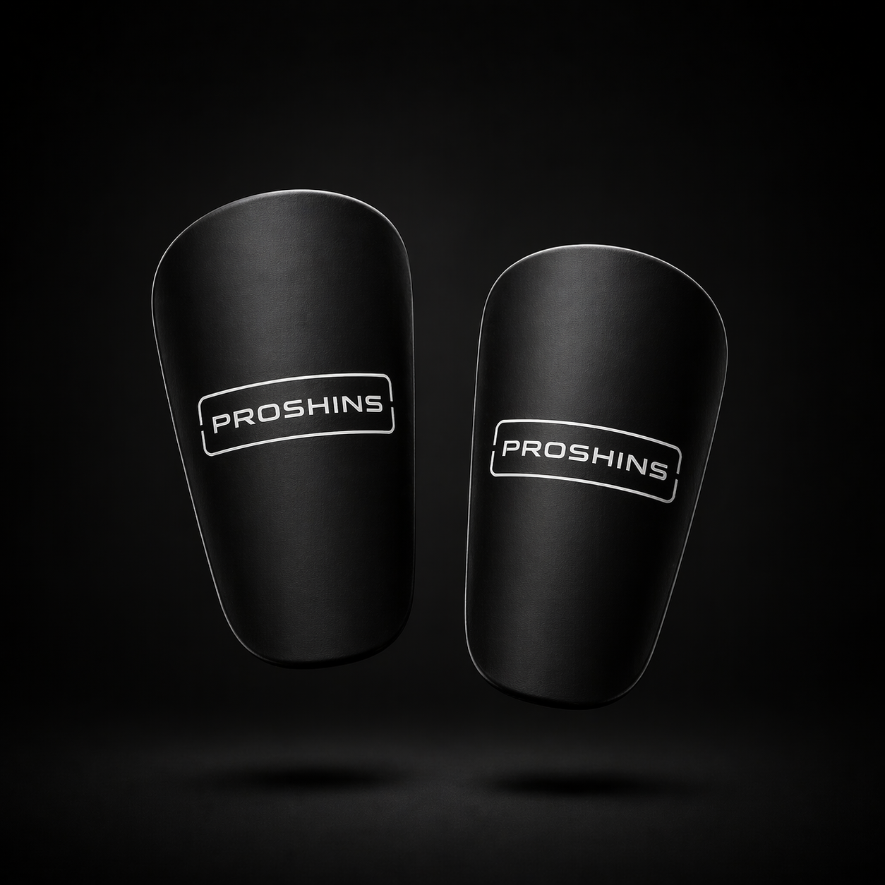 Pair of black shin guards with 'Proshins' branding on a dark background
